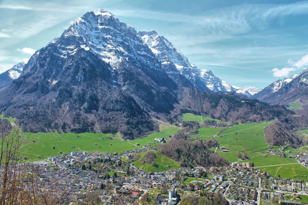 The town of Glarus on the valley floor, with the snow-covered pyramid of the Vorderglärnisch above it