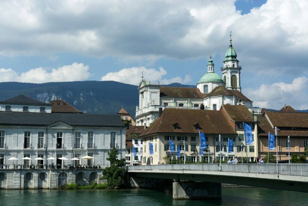 Die St.-Ursen-Kathedrale über der Aare in Solothurn, davor das Palais Besenval und die Kreuzackerbrücke