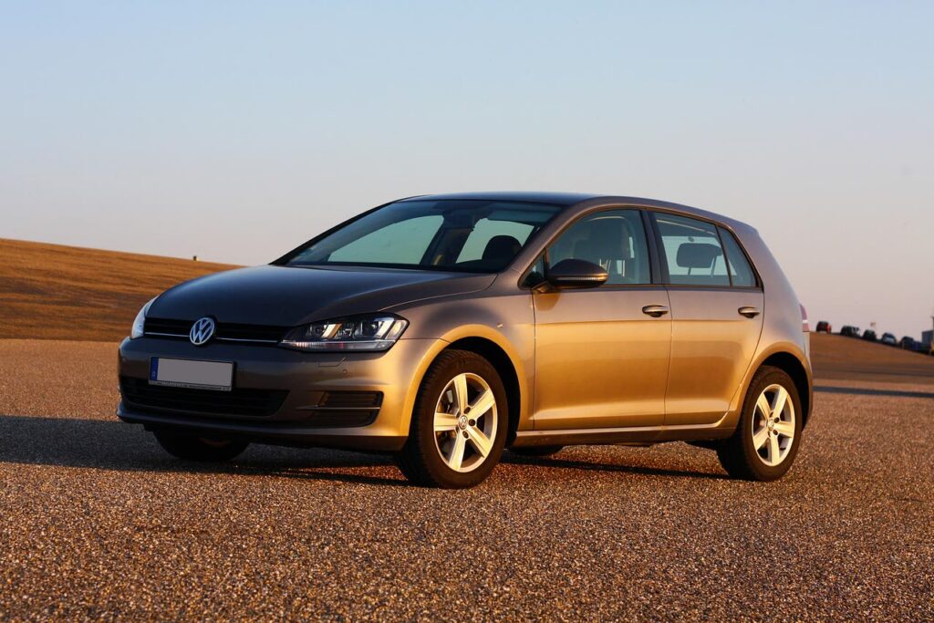 VW Golf nella calda luce della sera su un piazzale di ghiaia